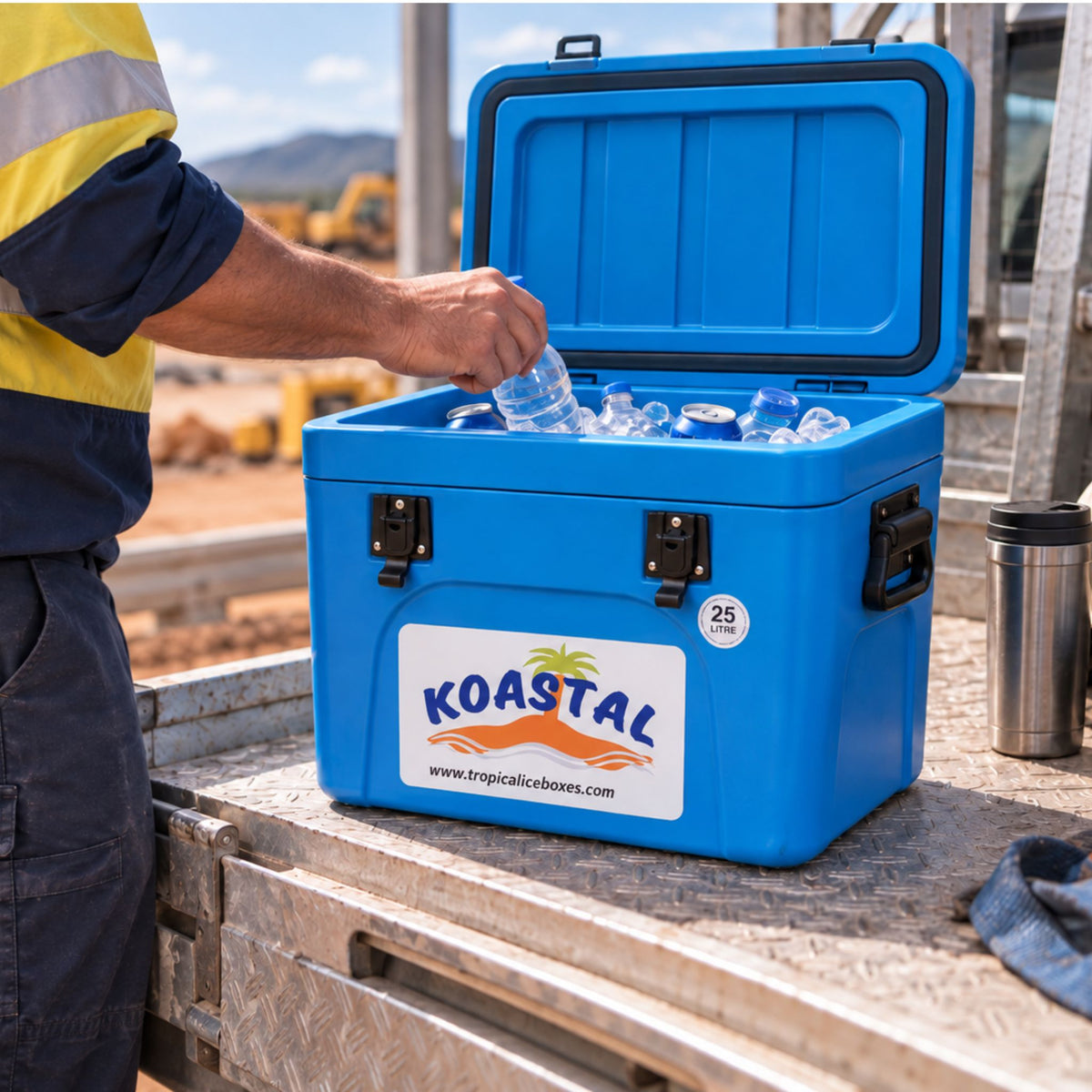 Koastal 25L blue ice box filled with ice and drinks on a worksite, with the lid open.